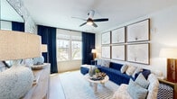 Located at 3200 Meadow Gate Ln in Davenport, Florida, this thoughtfully designed single-story residence offers 2 bedrooms and 3 bathrooms across a well-utilized floor plan. The open-concept living and kitchen area forms the heart of the home, where light wood-style flooring, recessed lighting, and ceiling fans create a bright and airy atmosphere. The kitchen is a standout feature, boasting white shaker cabinetry, a textured tile backsplash, stainless steel appliances including a French door refrigerator, and a navy-accented island with a white quartz countertop and seating for multiple guests, illuminated by sleek pendant lights. The living room offers large windows with views of the outdoors, dressed in rich navy drapes, and is anchored by a striking botanical-patterned accent wall. Each bedroom continues the coastal-inspired aesthetic, featuring bold tropical leaf wallpaper accent walls, ceiling fans, and generous natural light from well-positioned windows. The primary bathroom includes a glass-enclosed shower, white vanity cabinetry, and direct access to a well-organized walk-in closet. A dedicated laundry room houses a full-size washer and dryer. This residence combines functional design with elevated, resort-style finishes throughout.