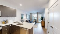 Located at 133 S Van Gordon St in Lakewood, Colorado, this one-bedroom, one-bathroom residence offers a well-organized, efficiently designed layout across a single floor. The open-concept living and kitchen area serves as the heart of the unit, where a peninsula with a white quartz countertop and bar seating connects the two spaces seamlessly. The kitchen is equipped with stainless steel appliances, including a French door refrigerator, range, and microwave, complemented by dark espresso cabinetry and a classic white subway tile backsplash. Light wood-style flooring extends throughout, contributing to a cohesive and modern aesthetic. The living area benefits from large windows and a glass door that invite abundant natural light and provide access to the outdoors. The bedroom features a ceiling fan, a sizable window with outdoor views, and direct access to the full bathroom. The bathroom includes a tub-shower combination with white subway tile surround, a dark-cabinetry vanity, and an adjacent walk-in closet, providing practical storage. Recessed lighting and clean white walls throughout give the unit a bright, contemporary ambiance.