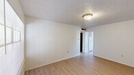 Located at 1701 N Avenue I in Crowley, Louisiana, this single-story unit offers a straightforward and functional layout across two bedrooms and two full bathrooms. Light wood-look flooring runs throughout the space, providing a clean and cohesive look in every room.

The living area greets you with a large window fitted with horizontal blinds, allowing natural light to fill the space, alongside a solid front entry door. The kitchen is efficiently designed with warm honey-toned wood cabinetry — both upper and lower — offering ample storage, paired with a double-basin sink, a white electric range, and a full-size refrigerator. Light countertops complement the cabinetry throughout.

The primary bedroom is generously proportioned, featuring a textured ceiling, a ceiling light fixture, and a double-door closet with dark wood-toned doors. The secondary bedroom is bright and airy, highlighted by a window with an outdoor view and a textured ceiling.

Both bathrooms are consistent in design, each featuring a single-sink vanity with warm wood cabinetry, a light countertop, a wall-mounted mirror, and a toilet. One bathroom includes a shower-tub combination with a curtain rod. The overall palette of white walls and light flooring creates a clean, neutral environment throughout.