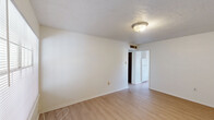 Located at 1701 N Avenue I in Crowley, Louisiana, this single-story unit offers a straightforward and functional layout across two bedrooms and two full bathrooms. Light wood-look flooring runs throughout the space, providing a clean and cohesive look in every room.

The living area greets you with a large window fitted with horizontal blinds, allowing natural light to fill the space, alongside a solid front entry door. The kitchen is efficiently designed with warm honey-toned wood cabinetry — both upper and lower — offering ample storage, paired with a double-basin sink, a white electric range, and a full-size refrigerator. Light countertops complement the cabinetry throughout.

The primary bedroom is generously proportioned, featuring a textured ceiling, a ceiling light fixture, and a double-door closet with dark wood-toned doors. The secondary bedroom is bright and airy, highlighted by a window with an outdoor view and a textured ceiling.

Both bathrooms are consistent in design, each featuring a single-sink vanity with warm wood cabinetry, a light countertop, a wall-mounted mirror, and a toilet. One bathroom includes a shower-tub combination with a curtain rod. The overall palette of white walls and light flooring creates a clean, neutral environment throughout.