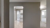 Located at 5685 Purdue Ave in Baltimore, MD, this single-floor 2-bedroom, 1-bathroom home offers a practical and well-organized layout. The kitchen is equipped with white cabinetry, dark stone-look countertops, a double sink, and full-size white appliances including a refrigerator and electric range, all set over neutral tile flooring. A connecting hallway links the main living areas efficiently, with a dedicated closet providing additional storage. The spacious primary bedroom features soft wall-to-wall carpeting, two windows that bring in natural light and outdoor greenery views, and a baseboard heating system. The second bedroom is similarly carpeted and bright, with its own window and baseboard heater, offering a comfortable and versatile space. Both bedrooms feature neutral gray-toned walls that complement the overall palette of the home. The full bathroom is clean and functional, featuring a soaking tub, toilet, pedestal sink, tile flooring, and a window for natural ventilation. Consistent neutral gray walls and white trim flow throughout the home, creating a cohesive and move-in-ready environment. The floor plan, as seen from the dollhouse view, reveals a sensible arrangement that maximizes the available living space.
