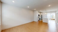 Located at 1801 Walt Whitman Dr, this three-bedroom, three-bathroom townhouse is thoughtfully laid out across three floors. The ground level houses an attached garage with an automatic opener, offering secure and convenient parking. The main living floor features an open-concept kitchen and living area with light hardwood-style flooring, recessed lighting, and large windows that allow natural light to fill the space. The kitchen is equipped with stainless steel appliances including a French door refrigerator, electric range, and built-in microwave, complemented by white upper cabinetry, warm wood-toned lower cabinets, marble-style countertops, and a kitchen island. A half bathroom with hardwood-style flooring is also conveniently located on this level. The upper floor hosts three bedrooms, each carpeted and featuring windows with blinds for natural light and privacy. The bedrooms are served by well-appointed bathrooms, including one with a tub-shower combination and brushed nickel fixtures. Each bedroom benefits from dedicated closet space, including a walk-in closet with built-in shelving. The clean, neutral palette throughout gives the home a bright, modern feel.