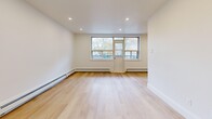 Located at 1 Marquette in Toronto's M6A neighbourhood, this thoughtfully renovated 2-bedroom, 1-bathroom unit offers a clean, modern aesthetic throughout. Light hardwood flooring flows seamlessly across the entire space, complemented by crisp white walls and recessed lighting that create a bright, airy atmosphere.

The galley-style kitchen is a standout feature, showcasing warm natural wood cabinetry paired with white lower cabinets, white quartz countertops, a gold-toned faucet, and full-height marble-look tile backsplash. Stainless steel appliances, including a refrigerator and range with overhead microwave, complete the functional layout.

The open living and dining area benefits from large windows overlooking the surrounding greenery, with baseboard heating and recessed pot lights adding comfort and style. Both bedrooms are well-proportioned, with light-filled windows, wood flooring, and mirrored sliding closet doors that enhance the sense of space.

The bathroom is elegantly finished with large-format marble-effect tiles surrounding a soaker tub, paired with brushed gold fixtures and a wood-accented vanity. A private balcony off the living area offers views of the tree-lined streetscape. Two closets and a dedicated entrance complete this well-appointed unit.