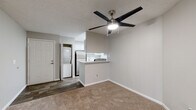 This single-floor residence offers a practical and well-appointed layout with a neutral color palette and textured ceilings throughout. The open living area is a central feature, anchored by a tile-surround fireplace and built-in shelving that adds both storage and visual interest. A ceiling fan with integrated lighting keeps the space comfortable, while a sliding glass door fitted with vertical blinds provides access to an outdoor area and allows natural light to filter in. Plush carpeting extends throughout the living and sleeping areas, contributing to a warm ambiance.

The kitchen is efficiently designed in a galley configuration, featuring white cabinetry, light stone countertops, stainless steel appliances including a refrigerator, electric range, microwave, and dishwasher, along with wood-look flooring and a walk-in pantry for ample storage. A pass-through counter connects the kitchen to the living space. An in-unit stacked washer and dryer is conveniently located nearby.

Two bathrooms serve the residence. One includes a soaking tub and shower combination with tiled surround and a window for natural light. The second features a separate glass-door shower, an extended vanity with white cabinetry, and wood-look tile flooring. The bedrooms are carpeted and bright, with windows providing outdoor views.