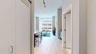 Located at 868 N Wells St in Chicago's vibrant River North neighborhood, this modern one-bedroom, one-bathroom unit offers a thoughtfully designed open layout with contemporary finishes throughout. Light hardwood flooring flows seamlessly across the entire space, complementing the neutral gray-and-white color palette that creates a clean, cohesive aesthetic.

The open-concept kitchen and living area serves as the heart of the unit. The kitchen features flat-front wood-grain cabinetry, a tiled subway backsplash, a gas cooktop, and a marble-topped island with bar seating — ideal for both cooking and casual dining. The adjoining living area is anchored by floor-to-ceiling windows that bathe the space in natural light and frame views of the Chicago cityscape. Track lighting overhead provides additional illumination.

The bedroom is a well-proportioned retreat with large windows offering city views and ample natural light. Built-in wardrobe storage and direct access to the bathroom add to its functional design. The bathroom is finished with large-format tile, a glass-enclosed walk-in shower, a vanity with an illuminated mirror, and understated gray cabinetry. Every detail reflects a modern, urban sensibility well-suited to city living.
