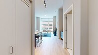 Located at 868 N Wells St in Chicago's vibrant River North neighborhood, this modern one-bedroom, one-bathroom unit offers a thoughtfully designed open layout with contemporary finishes throughout. Light hardwood flooring flows seamlessly across the entire space, complementing the neutral gray-and-white color palette that creates a clean, cohesive aesthetic.

The open-concept kitchen and living area serves as the heart of the unit. The kitchen features flat-front wood-grain cabinetry, a tiled subway backsplash, a gas cooktop, and a marble-topped island with bar seating — ideal for both cooking and casual dining. The adjoining living area is anchored by floor-to-ceiling windows that bathe the space in natural light and frame views of the Chicago cityscape. Track lighting overhead provides additional illumination.

The bedroom is a well-proportioned retreat with large windows offering city views and ample natural light. Built-in wardrobe storage and direct access to the bathroom add to its functional design. The bathroom is finished with large-format tile, a glass-enclosed walk-in shower, a vanity with an illuminated mirror, and understated gray cabinetry. Every detail reflects a modern, urban sensibility well-suited to city living.