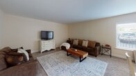 Located at 201 E Cook Ave in Libertyville, IL, this single-floor unit offers a well-organized and comfortable layout. The open living and dining area is generously proportioned, featuring plush carpeting, a ceiling fan, and a window that brings in natural light. The space comfortably accommodates a full seating arrangement alongside a dining set, creating a versatile gathering area.

The kitchen has been thoughtfully updated with white shaker-style cabinetry, subway tile backsplash, and granite countertops. A peninsula with bar seating serves as both a prep space and casual dining spot. Stainless steel appliances, including a range, microwave, and dishwasher, complement the modern aesthetic, while warm-toned hardwood-style flooring and a copper pendant light add character.

The unit includes two bedrooms, each carpeted and fitted with windows offering natural light. The primary bedroom features a walk-in closet, while the second bedroom includes a built-in closet and space for a desk or vanity area. Both bathrooms are finished with tile surrounds, dark wood vanities, and shower-tub combinations, providing a clean and functional design throughout. The overall ambiance is warm and residential, suited for comfortable everyday living.