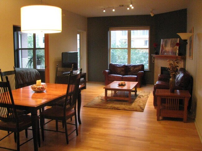 Gran sala abierta con chimenea a gas, puerta al patio y comedor. - 360 W Washington Ave