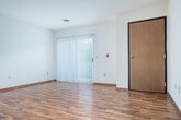 Located at 2333 Columbus Ln in Madison, WI, this single-floor, 2-bedroom, 2-bathroom home offers a practical and comfortable layout. The open living room is a welcoming space featuring warm hardwood-style flooring, crisp white walls, and a sliding glass door with vertical blinds that provides natural light and access to an outdoor area. The kitchen is well-appointed with oak cabinetry, tile flooring, and a full suite of white appliances including a range, dishwasher, and refrigerator, complemented by a skylight-style overhead fixture that brightens the space. A hallway connects the main living area to the two bedrooms, each carpeted for comfort. The primary bedroom is generously sized, featuring a mirrored sliding closet and a window with natural views. The second bedroom benefits from two windows, filling the room with natural light. Both bathrooms are finished with tile flooring and oak vanities with mirrors. A spacious walk-in closet with wire shelving provides ample storage. The home's layout is efficient and well-connected, with two additional closets offering further storage throughout.