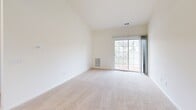 Located at Marley Manor in Salisbury, Maryland, this single-floor residence offers a clean, neutral aesthetic throughout with a thoughtfully arranged open floor plan. The living area is generously proportioned with plush wall-to-wall carpeting and soaring vaulted ceilings that lend an airy, open feel to the space. It connects seamlessly to the galley-style kitchen, which is outfitted with white cabinetry, light countertops, stainless steel appliances including a gas range, microwave, and refrigerator, and durable wood-look flooring. A breakfast bar provides a natural transition between the kitchen and living areas. The primary bedroom is a standout feature, boasting vaulted ceilings, a large window for natural light, and access to a walk-in closet. Additional bedrooms are well-sized with carpeting and ample natural light from windows overlooking the surrounding neighborhood. The bathrooms include full tub-shower combinations with clean, white surround panels and chrome fixtures. A dedicated laundry room houses a full-size washer and dryer and includes overhead wire shelving for added storage. Carpeted hallways with overhead lighting connect all areas of the home, creating a cohesive and functional living environment throughout.