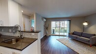 Located at 520 Mansion Ct in Santa Clara, CA, this single-floor residence offers a thoughtfully designed open-concept layout with consistent wood-style flooring flowing throughout the space. The living area is bright and welcoming, anchored by large sliding glass doors that open onto a private balcony, allowing abundant natural light and outdoor views of surrounding greenery. A wall-mounted mini-split unit provides efficient climate control in the living space.

The galley-style kitchen is well-appointed with white cabinetry, subway tile backsplash, dark countertops, and a full suite of stainless steel appliances including a range, over-the-range microwave, refrigerator, and dishwasher. A peninsula counter with seating potential connects the kitchen to the main living area, enhancing the open feel.

The bedroom is calm and spacious, featuring neutral tones, dark hardwood-style flooring, and a window that frames views of the exterior landscape, filling the room with soft natural light. The bathroom includes wood-style flooring and a shower with a decorative curtain, maintaining the cohesive modern aesthetic found throughout the unit. In-unit laundry connections are also visible, adding practical convenience to this well-finished Santa Clara residence.