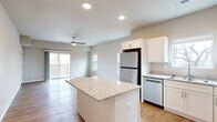 Located at 1735 E Valley Water Mill Rd in Springfield, MO, this 2-bedroom, 2-bathroom single-floor residence offers a clean, modern aesthetic throughout. The open-concept kitchen and living area serves as the heart of the home, anchored by a granite-topped central island and complemented by crisp white shaker cabinetry, stainless steel appliances, and light hardwood-style flooring. Recessed lighting and a ceiling fan enhance the bright, airy feel of the shared living space, which opens to a private balcony through sliding glass doors. The primary bedroom features plush carpeting, a ceiling fan, dual closet doors, natural light from a large window, and direct access to its own bathroom. The second bedroom also features soft carpeting, a ceiling fan, and generous natural light through multiple windows. Both bathrooms are finished with granite-topped vanities and hardwood-style flooring, maintaining a cohesive, polished look. Additional conveniences include a dedicated laundry area, hallway access connecting all rooms, and ample closet storage. Neutral wall tones and consistent finishes throughout create a harmonious and welcoming living environment.