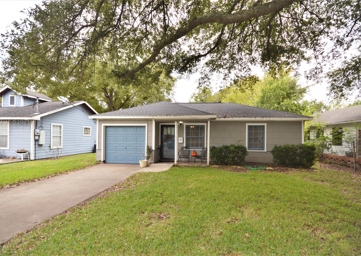 Charming exterior with porch and large mature trees - 2119 N Grand Blvd