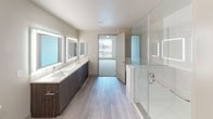 Located at 10110 Foothill Blvd in Rancho Cucamonga, CA, this modern single-floor residence showcases a clean, contemporary design throughout. The open-concept kitchen is a standout feature, equipped with stainless steel appliances including a gas range, built-in microwave, refrigerator, and dishwasher. Rich, dark wood cabinetry lines the walls from floor to ceiling, complemented by light quartz countertops, a subway tile backsplash, and a central island ideal for dining or meal prep. A stylish pendant light adds a finishing touch to the kitchen's modern aesthetic. The living areas feature light wood-look flooring and ceiling fans, creating a bright and airy atmosphere. Multiple bedrooms are finished with plush carpet, ceiling fans, and large windows with blinds that invite natural light and outdoor views. The primary bathroom is generously proportioned, offering a dual-sink vanity with illuminated mirrors, a glass-enclosed walk-in shower with tile surround, and wood-look flooring. A secondary bathroom includes a tiled shower-tub combo and a sleek vanity with an LED-backlit mirror. Neutral tones and clean lines unify the space, delivering a polished, move-in-ready living environment.