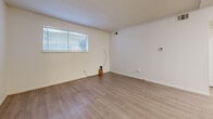 Located at 2414 S Glendale St in Wichita, Kansas, this single-floor, one-bedroom, one-bathroom unit offers a practical and well-organized layout. The combined kitchen and living area forms the heart of the space, featuring light wood-tone flooring throughout and a clean, neutral color palette of crisp white walls. The kitchen is well-equipped with warm oak cabinetry offering generous upper and lower storage, a full suite of black appliances including a refrigerator, electric range, microwave, and dishwasher, along with a double-basin sink beneath under-cabinet lighting. The open layout allows the kitchen to flow naturally into the living area, which benefits from ceiling-mounted lighting and ventilation fixtures. The bedroom is a comfortable, private retreat finished with plush carpeting and a window fitted with blinds that allow natural light while maintaining privacy. A dedicated closet provides additional storage. The bathroom features a wood-vanity with an integrated sink, a large mirror, and light flooring. A hallway connects the main living spaces, completing the functional floor plan. The unit includes a separate closet, adding practical storage for daily needs.