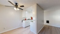 Located at 13707 Doty Ave in Hawthorne, CA, this one-bedroom, two-bathroom unit offers a thoughtfully organized single-level floor plan that makes efficient use of its space. Light wood-style flooring flows throughout, complementing the neutral, warm-toned walls and textured ceilings found in every room.

The combined living and dining area forms the heart of the unit, bathed in natural light from multiple windows dressed with vertical blinds. A ceiling fan with integrated lighting anchors the space, while a wall-mounted heater provides climate control. The open layout allows for flexible furniture arrangements to suit both lounging and dining needs.

The kitchen is defined by a partial dividing wall, creating a semi-open galley layout. White cabinetry, a clean countertop, and a sink with ample storage below keep the space practical and bright.

The bedroom is a comfortable, sunlit retreat featuring a wide sliding-door closet and a window that draws in generous natural light, casting warm rays across the light flooring.

Two full bathrooms serve the unit, one of which features a full bathtub with a shower curtain and a high clerestory window that introduces natural light while maintaining privacy.

The unit's clean, minimalist aesthetic, consistent finishes, and well-distributed natural light throughout create a bright and functional living environment in the heart of Hawthorne.