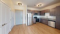 Located at 1222 Patrick Henry Dr in Blacksburg, VA, this 2-bedroom, 2-bathroom residence offers a thoughtfully designed single-floor layout with modern finishes throughout. Light wood-tone flooring runs seamlessly across all living areas, lending the space a clean, cohesive aesthetic.

The kitchen serves as a functional centerpiece, outfitted with rich dark-stained cabinetry, granite-style countertops, and a full suite of stainless steel appliances including a refrigerator, electric range, microwave, and dishwasher. A peninsula countertop provides additional prep and dining space, while flush-mount pendant lighting adds a warm ambiance near the entryway.

Both bedrooms feature neutral walls, light-filled windows with blinds, and ceiling fans for year-round comfort. The primary bedroom benefits from two windows framing views of surrounding greenery and connects to a dedicated walk-in closet equipped with wire shelving. A second walk-in closet with multi-tier wire shelving provides generous storage for the second bedroom.

The two bathrooms are finished with granite-topped vanities and dark cabinetry, complementing the overall design. One bathroom includes a full tub-shower combination with a curved curtain rod and accessibility grab bar. The primary bathroom opens directly into its walk-in closet, creating a practical and private en-suite flow. Wood-look flooring continues throughout both bathrooms, maintaining a unified design.