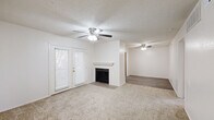 Located at 5302 11th St in Lubbock, TX, this single-story 2-bedroom, 2-bathroom unit offers a practical and well-organized layout. The living room features neutral-toned carpet and connects to a hallway that flows into the rest of the home. Wood-look flooring runs through the kitchen and entry areas, providing a clean contrast to the carpeted bedrooms. The kitchen includes a refrigerator and direct exterior access through a windowed door, allowing for natural light. Both bedrooms are carpeted and feature ceiling fans, windows with blinds for natural light and privacy, and dedicated closets with built-in shelving and hanging rods for ample storage. The primary bedroom is comfortably sized with its own closet. The two bathrooms are finished with white cabinetry, quartz-style countertops, brushed nickel fixtures, and large mirrors. One bathroom features a tub-shower combo, while the other includes a single vanity with a framed mirror. Throughout the unit, textured ceilings, neutral wall tones, and consistent finishes create a cohesive and functional living environment well-suited for everyday comfort.
