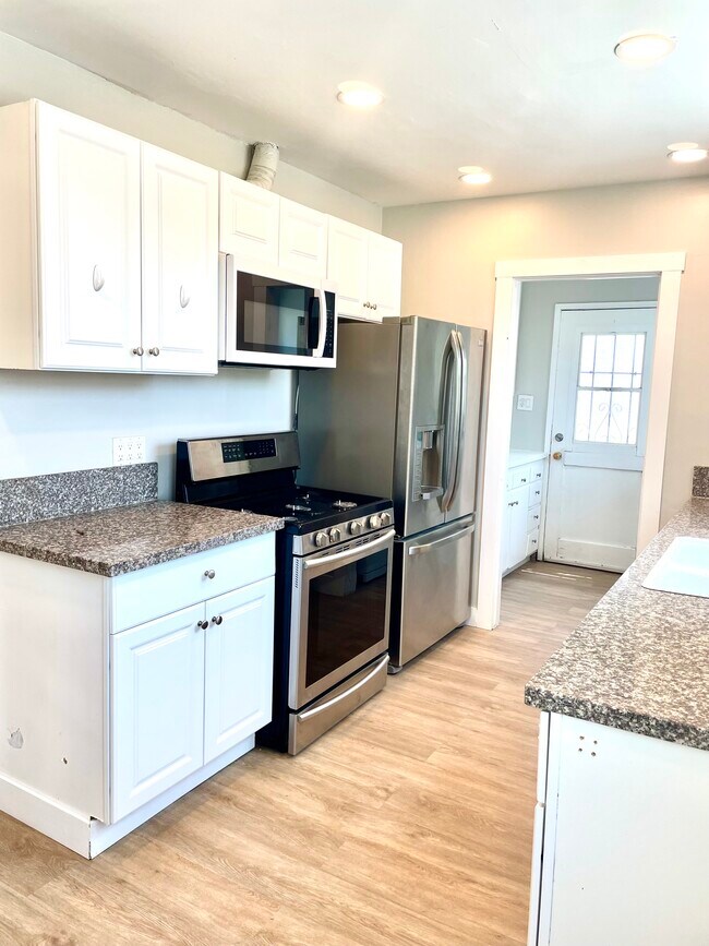Cocina con lavadero adyacente y salida al patio trasero. - 10134 Memory Park Ave