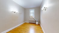 Located at 260 1/2 Dalhousie St in Ottawa's historic Lowertown neighbourhood, this single-floor unit offers three bedrooms, one bathroom, and a practical layout across a compact but well-organized footprint. Warm hardwood flooring runs throughout the bedrooms and hallways, lending the space a classic character consistent with the building's older architecture. A long, narrow hallway connects the rooms, creating a clear and efficient flow through the unit. The three bedrooms are modestly sized, each featuring neutral painted walls and classic panel doors; the primary bedroom includes wall-mounted light fixtures and a window with natural light. Radiator heating units are present in multiple rooms, including the bedrooms and bathroom, reflecting the building's traditional heating system. The kitchen is a highlight of the unit, featuring white cabinetry, a stainless steel sink with marble-style countertops, light tile flooring, and a distinctive arched architectural detail that frames the eating or prep nook. A stainless steel range completes the cooking space. The bathroom is finished with white subway tile, a soaking tub, and terracotta floor tile, with a radiator and a frosted window providing ventilation. Overall, the unit presents a clean, functional living space with charming older details throughout.