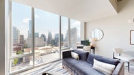 Located in the heart of Nashville's midtown neighborhood at 805 Church Street, this contemporary studio unit offers an efficient, thoughtfully designed single-floor layout. The combined living and dining area serves as the centerpiece of the space, anchored by dramatic floor-to-ceiling windows that flood the room with natural light and frame sweeping, unobstructed views of the Nashville downtown skyline. The open-concept design creates a seamless flow between the living, dining, and kitchen areas, with light hardwood flooring running throughout the main spaces. The kitchen features dark cabinetry with stainless steel appliances, including a refrigerator, microwave, and dishwasher, all accessible via a well-organized galley-style corridor. The sleeping area is quietly positioned away from the main living space, offering a built-in closet with shelving for ample storage. The full bathroom presents a clean, modern aesthetic with a backlit vanity mirror, sleek gray cabinetry, a white undermount sink, and a glass-enclosed shower. An in-unit laundry area and a dedicated entrance add further convenience. The overall ambiance is polished and contemporary, with neutral tones, high ceilings, and panoramic city views defining the character of this urban Nashville residence.