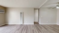 Located at 3971 W Orange Ave in Anaheim, California, this one-bedroom, one-bathroom unit offers a practical and well-organized layout across a single floor. The interior features light-toned luxury vinyl plank flooring throughout, complemented by neutral warm-gray walls and clean white baseboards that create a cohesive, modern aesthetic.

The combined kitchen and living area serves as the heart of the unit. The kitchen is equipped with white upper and lower cabinetry, a speckled stone-look countertop, a stainless steel sink, a gas range, and a dishwasher — all finished in white for a clean, uniform look. A peninsula counter separates the kitchen from the living space, providing additional prep or dining space. The living area is open and airy, with a sliding glass door offering direct access to a landscaped outdoor area and allowing generous natural light to filter in.

The bedroom is a comfortable, well-proportioned space featuring a large window dressed with vertical blinds that diffuse natural light evenly. A dedicated closet provides practical storage. The full bathroom includes a tub-shower combination with a crisp white surround, a toilet, and matching LVP flooring for continuity. Textured ceilings are present throughout the unit, adding a classic residential character to the overall design.