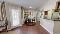This thoughtfully designed 1-bedroom, 1-bathroom residence in Shreveport, Louisiana offers a comfortable and functional single-story layout. The open-concept living, dining, and kitchen area serves as the heart of the home, featuring rich hardwood-style flooring, crown molding, and ceiling fans that lend a classic, polished character. Large windows dressed with curtains invite natural light throughout the main living space, creating a warm and welcoming ambiance. The kitchen is equipped with stainless steel appliances, including a range, over-the-range microwave, and refrigerator, complemented by granite-style countertops and warm wood cabinetry, along with a dedicated pantry for added storage. A cozy dining area with space for a bistro-style table sits adjacent to the kitchen. The bedroom offers plush carpeting, a ceiling fan, and natural light from a window, with access to two closets providing generous storage. The full bathroom features a clean, tiled tub-shower combination with wood cabinetry. A dedicated in-unit laundry area with side-by-side washer and dryer hookups adds everyday convenience. The unit also includes a private patio, perfect for outdoor relaxation.