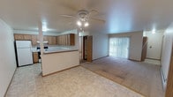 Located at 1415 Tullar Rd in Neenah, Wisconsin, this single-floor unit offers a practical and comfortable layout designed for everyday living. The open-concept kitchen and living area serve as the heart of the space, where warm oak cabinetry, a peninsula with a double stainless steel sink, white appliances including a refrigerator, electric range, and dishwasher, and light-toned countertops come together in a functional kitchen. The adjacent living area features tile-style flooring that transitions into plush carpeting, a ceiling fan with light fixture, and sliding glass doors with vertical blinds that lead to an outdoor patio, allowing natural light to fill the room. Multiple bedrooms are finished with wall-to-wall carpet, ceiling fans, and baseboard heating, providing a cozy atmosphere. One bedroom includes direct access to a dedicated laundry area, adding convenience to daily routines. Generous closet space is available, including a large built-in shelving unit ideal for storage. The bathroom is cleanly appointed with a full tub-shower combination, a vanity with oak cabinetry, and tile flooring. Neutral wall tones and consistent warm wood trim throughout give the unit a cohesive, move-in-ready feel.