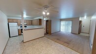 Located at 1415 Tullar Rd in Neenah, Wisconsin, this single-floor unit offers a practical and comfortable layout designed for everyday living. The open-concept kitchen and living area serve as the heart of the space, where warm oak cabinetry, a peninsula with a double stainless steel sink, white appliances including a refrigerator, electric range, and dishwasher, and light-toned countertops come together in a functional kitchen. The adjacent living area features tile-style flooring that transitions into plush carpeting, a ceiling fan with light fixture, and sliding glass doors with vertical blinds that lead to an outdoor patio, allowing natural light to fill the room. Multiple bedrooms are finished with wall-to-wall carpet, ceiling fans, and baseboard heating, providing a cozy atmosphere. One bedroom includes direct access to a dedicated laundry area, adding convenience to daily routines. Generous closet space is available, including a large built-in shelving unit ideal for storage. The bathroom is cleanly appointed with a full tub-shower combination, a vanity with oak cabinetry, and tile flooring. Neutral wall tones and consistent warm wood trim throughout give the unit a cohesive, move-in-ready feel.