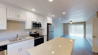 This thoughtfully renovated single-floor unit offers 2 bedrooms and 2 bathrooms with contemporary upgrades throughout. The kitchen serves as a central highlight, showcasing crisp white shaker-style cabinetry, granite-style countertops, and a full suite of stainless steel appliances including a range, microwave, dishwasher, and refrigerator. A kitchen island provides additional prep and dining space, while recessed lighting illuminates the area efficiently. Wood-look plank flooring runs throughout the main living areas, adding warmth and durability.

The open living area is bright and spacious, featuring a ceiling fan, recessed lighting, and a sliding glass door that invites natural light and outdoor access. Both bedrooms are comfortably sized, carpeted for comfort, and equipped with ceiling fans and windows that allow for natural light. Baseboard heating is present in the bedrooms for added comfort.

Each of the two bathrooms features a tub-shower combination with a curved curtain rod, brushed nickel fixtures, and wood-look flooring, maintaining the clean, updated aesthetic carried throughout the unit. Neutral wall tones and consistent finishes provide a cohesive, move-in-ready feel across the entire space.