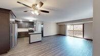 Located at 907 Vale Park Rd in Valparaiso, Indiana, this single-floor residence offers a thoughtfully designed open-concept layout with contemporary finishes throughout. The main living area is bright and spacious, featuring wood-style plank flooring, neutral-toned walls, and a ceiling fan with integrated lighting. A large sliding glass door floods the space with natural light and opens to a private balcony, providing outdoor views and additional ventilation.

The kitchen is a standout feature, showcasing rich dark-stained cabinetry with brushed nickel hardware, light granite countertops, and a classic white subway tile backsplash. Stainless steel appliances — including a gas range, microwave, and dishwasher — complement the modern aesthetic. A peninsula with an extended countertop provides additional prep space and casual seating, seamlessly connecting the kitchen to the living area.

A separate room with its own sliding glass door and vertical blinds offers flexibility as a bedroom or additional living space, with continued access to outdoor views. The bathroom is clean and functional, featuring a single-sink vanity with dark cabinetry, a large mirror, and a full tub-shower combination with brushed nickel fixtures. Consistent wood-style flooring and a cohesive neutral color palette unify the entire space.