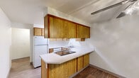 Located in Tigard, Oregon, this single-floor, two-bedroom, two-bathroom home offers a practical and well-organized layout. The combined kitchen and dining area is a central feature, equipped with warm wood-toned cabinetry, a built-in cooktop, a double sink, and a peninsula counter that provides additional workspace. White appliances, including a refrigerator and oven, complement the clean, light countertops throughout.

The two bedrooms are carpeted and filled with natural light from large windows with blinds. The primary bedroom, a generously sized room, includes a mirrored sliding-door closet and a baseboard heating unit. The second bedroom also features carpet flooring and a bright window with outdoor views. Both rooms maintain a neutral color palette with textured ceilings.

The two bathrooms are finished with wood-toned vanity cabinetry and light countertops. One bathroom features a tiled tub-and-shower combination with chrome fixtures, while the other includes a vanity with a wide mirror and overhead lighting.

Additional spaces include a dedicated laundry room, a utility room, an entrance, and a patio for outdoor access. Hardwood-style flooring flows through the bathrooms and kitchen, while carpet covers the living and sleeping areas, creating a cohesive and comfortable home environment throughout.