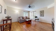This well-appointed 1-bedroom, 1-bathroom unit offers an efficient and comfortable layout designed to maximize every square foot. The living room serves as the heart of the unit, featuring warm hardwood flooring, a textured ceiling, a ceiling fan, and multiple windows fitted with blinds that allow for natural light while maintaining privacy. The space is open enough to accommodate a seating area and additional furnishings with ease.

The kitchen is compact yet functional, showcasing light wood cabinetry, granite countertops, a tile backsplash in a classic diagonal pattern, and black appliances including a dishwasher and range. Hardwood flooring continues seamlessly from the living area into the kitchen.

The bedroom is carpeted for comfort and includes a ceiling fan, multiple windows for natural light, and closet access, providing a quiet and restful retreat. The full bathroom features tile flooring, a shower-tub combination, a stylish vanity with a dark countertop, and classic wall décor.

A standout feature of this unit is the private balcony, which overlooks a lush, tree-lined outdoor setting with open green space and views of the surrounding community. Access is provided via an exterior metal staircase with railing. Two closets offer practical storage throughout the unit.