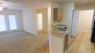 Located at 2850 Courtney Creek Blvd in Durham, North Carolina, this single-floor residence offers a practical and comfortable layout designed for everyday living. The kitchen serves as a central focal point, featuring warm wood cabinetry, a double-basin sink, and a curved peninsula countertop with a light stone-toned surface that provides additional prep space and a natural divide between the kitchen and the adjoining living area. The flooring transitions from hardwood-style planks in the kitchen and entry areas to plush carpet throughout the living spaces, adding warmth and comfort underfoot. The open-concept design allows for a seamless flow between the kitchen and the spacious living area, creating a sense of openness and connectivity. Neutral wall tones in a soft cream palette lend the space a clean, bright feel throughout. A hallway visible from the main living area leads to additional rooms, offering functional separation of living and private spaces. The layout is thoughtfully organized to maximize usability, with ample wall space and natural transition points between areas. Overall, the residence presents a straightforward, move-in-ready environment well-suited for comfortable day-to-day living in the Durham community.
