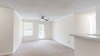 Located at 50 Greenleaf Road in Conyers, Georgia, this single-floor, 2-bedroom, 1-bathroom home offers a well-organized and functional layout throughout. The combined kitchen and living area serves as the heart of the home, with the kitchen featuring white cabinetry, light countertops with a breakfast bar, wood-look flooring, and black stainless appliances including a full-size refrigerator. The living room is carpeted and benefits from natural light through a large window and glass door that opens to a private wooden deck, complete with a ceiling fan and crown molding for added character. Both bedrooms are carpeted and filled with natural light from sizable windows, each equipped with ceiling fans. The primary bedroom includes access to a dedicated closet, while a second closet provides additional storage. The bathroom features a full tub-shower combo with white tile surround and hardwood-style flooring. A dedicated laundry area accommodates a full-size side-by-side washer and dryer. The home maintains a clean, neutral palette with textured ceilings and white trim throughout, creating a bright and cohesive living environment.