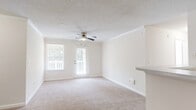 Located at 50 Greenleaf Road in Conyers, Georgia, this single-floor, 2-bedroom, 1-bathroom home offers a well-organized and functional layout throughout. The combined kitchen and living area serves as the heart of the home, with the kitchen featuring white cabinetry, light countertops with a breakfast bar, wood-look flooring, and black stainless appliances including a full-size refrigerator. The living room is carpeted and benefits from natural light through a large window and glass door that opens to a private wooden deck, complete with a ceiling fan and crown molding for added character. Both bedrooms are carpeted and filled with natural light from sizable windows, each equipped with ceiling fans. The primary bedroom includes access to a dedicated closet, while a second closet provides additional storage. The bathroom features a full tub-shower combo with white tile surround and hardwood-style flooring. A dedicated laundry area accommodates a full-size side-by-side washer and dryer. The home maintains a clean, neutral palette with textured ceilings and white trim throughout, creating a bright and cohesive living environment.
