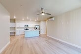 Located at 3100 N Akers St in Visalia, California, this single-story 2-bedroom, 2-bathroom home offers a thoughtfully designed layout across a comfortable footprint. The open-concept great room seamlessly integrates the living, dining, and kitchen areas, creating an airy and connected space. Light-toned luxury vinyl plank flooring runs throughout the main living areas, complemented by recessed lighting and a ceiling fan overhead. A wall-mounted mini-split unit provides efficient climate control.

The kitchen is outfitted with crisp white shaker cabinetry, light quartz countertops, a central island, and stainless steel appliances including a range, built-in microwave, and French door refrigerator. A dedicated pantry adds extra storage convenience.

Both bedrooms feature ceiling fans and plush carpeting, with the primary bedroom offering a comfortable, well-proportioned layout. The two bathrooms are finished with white vanity cabinetry, clean countertops, and light wood-tone flooring. Three closets provide ample storage throughout the home.

Additional highlights include an attached garage with an automatic opener, an in-unit laundry area, and a covered concrete patio accessible via sliding glass door — ideal for outdoor relaxation. A hallway connects the private quarters efficiently to the main living space.