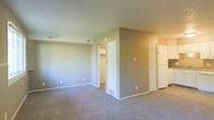 This single-floor residential unit offers a clean, functional layout designed with everyday comfort in mind. The interior is finished with wall-to-wall carpeting throughout the main living area, providing a soft and warm underfoot feel. Neutral beige and taupe wall tones create a calm, understated ambiance that lends itself well to a variety of furnishing styles.

The space features a central dividing wall that defines distinct areas within the open floor plan, adding architectural structure without fully closing off the rooms. Visible from the main living area are two notable storage features: a walk-in closet with interior shelving, ideal for organized storage, and a set of double doors leading to additional closet or utility space. A wall-mounted thermostat indicates a central HVAC system, ensuring year-round climate control.

Ceiling-mounted HVAC vents are positioned throughout, contributing to efficient air distribution across the space. White trim and door surrounds provide a crisp contrast to the neutral walls, lending a tidy, well-maintained appearance. The layout is straightforward and accessible, making it a practical and welcoming living environment.