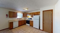 This three-floor property in Kalamazoo, Michigan, offers a practical and well-organized layout across multiple levels, connected by a central carpeted staircase with wood railings. The kitchen is equipped with warm oak cabinetry extending to the upper walls, providing generous storage throughout. Light-toned countertops offer ample workspace, and appliances include a gas range with an overhead ventilation hood, a dishwasher, and a full-size refrigerator. Tile flooring and a textured ceiling complete the kitchen's functional design. A window allows natural light into the space.

The bedrooms feature neutral carpet flooring, textured ceilings, and windows fitted with vertical blinds, allowing adjustable natural light. Wood windowsills and trim add a consistent design detail throughout. The rooms offer a clean, open feel suited for a variety of uses.

Multiple bathrooms are distributed across the floors. One includes a tiled tub-shower combination, toilet, and vanity with an oak cabinet base and mirror. Another full bathroom features a shower-tub unit and toilet with tile flooring, while a third presents a compact half-bath configuration. Each bathroom maintains a clean, straightforward design with tile flooring and wood-trimmed doorways consistent with the rest of the home.