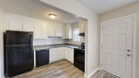 This two-story, 2-bedroom, 2-bathroom home in Rome, Georgia offers a practical and well-organized layout spread across two evenly sized floors. The main level features a welcoming living room with wood-look laminate flooring, a large window that fills the space with natural light, and a carpeted staircase leading to the upper level. Adjacent to the living room is a dedicated dining area that flows seamlessly into the kitchen. The kitchen is equipped with white cabinetry, dark countertops, and a full suite of black appliances including a refrigerator, dishwasher, and electric range, complemented by a window above the sink. A utility room and laundry area round out the first floor. Upstairs, both bedrooms feature plush carpeting, ceiling fans, and windows with outdoor views, providing a comfortable and airy feel. The primary bedroom is generously sized and includes dedicated closet space. The two bathrooms are functional and clean, with one featuring a tiled tub-shower combo and wood-look flooring. Three closets throughout the home provide ample storage. Textured ceilings are present throughout, adding a classic residential character to the space.