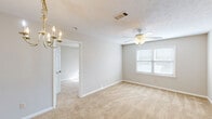 Located at 20401 Trillery Lane in Phenix City, Alabama, this single-floor, 2-bedroom, 1-bathroom home offers a practical and comfortable layout. The living and dining area features warm beige carpet, neutral-toned walls, and a classic brass chandelier, creating an inviting atmosphere. A ceiling fan with a light kit adds both function and comfort to the main living space, which also benefits from natural light through a window.

The kitchen is equipped with white cabinetry accented by wood-tone trim, light laminate countertops, a double stainless steel sink, and a black dishwasher, providing ample storage and workspace.

The spacious primary bedroom is generously sized, offering plush carpeting, a ceiling fan, a window for natural light, and access to a closet. The second bedroom also features carpet flooring, a ceiling fan, and a window that allows in natural light, making it a bright and functional space.

The full bathroom includes a single-sink vanity with a large mirror, tile flooring in a warm earth tone, and a tub-shower combination. A hallway connects the main rooms, contributing to the home's efficient and straightforward floor plan. Overall, the home presents a clean, neutral palette throughout.