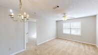Located at 20401 Trillery Lane in Phenix City, Alabama, this single-floor, 2-bedroom, 1-bathroom home offers a practical and comfortable layout. The living and dining area features warm beige carpet, neutral-toned walls, and a classic brass chandelier, creating an inviting atmosphere. A ceiling fan with a light kit adds both function and comfort to the main living space, which also benefits from natural light through a window.

The kitchen is equipped with white cabinetry accented by wood-tone trim, light laminate countertops, a double stainless steel sink, and a black dishwasher, providing ample storage and workspace.

The spacious primary bedroom is generously sized, offering plush carpeting, a ceiling fan, a window for natural light, and access to a closet. The second bedroom also features carpet flooring, a ceiling fan, and a window that allows in natural light, making it a bright and functional space.

The full bathroom includes a single-sink vanity with a large mirror, tile flooring in a warm earth tone, and a tub-shower combination. A hallway connects the main rooms, contributing to the home's efficient and straightforward floor plan. Overall, the home presents a clean, neutral palette throughout.