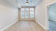 Located at 120 Hollis Rd in Charlotte, NC, this 1-bedroom, 2-bathroom residence offers a thoughtfully designed single-floor layout that maximizes functionality and comfort. Light wood-tone flooring flows throughout the living areas and bedroom, complemented by neutral warm-gray walls that create a clean, modern aesthetic.

The kitchen is a standout feature, showcasing floor-to-ceiling gray shaker cabinetry with black hardware, striking dark quartz countertops, a white subway tile backsplash, and stainless steel appliances including a French door refrigerator and dishwasher. A built-in wine rack adds a refined touch to the cabinetry design.

The spacious primary bedroom is filled with natural light through a large multi-pane window with transom panels and is equipped with a ceiling fan. A walk-in closet with built-in shelving provides generous storage, connecting seamlessly to the en-suite bathroom.

The bathrooms feature marble-look tile flooring, white vanity cabinetry with dark countertops, and accessible design elements including grab bars — reflecting both style and practicality. A separate tiled shower completes the primary bath. The overall ambiance of this residence is bright, modern, and move-in ready, offering comfortable urban living in Charlotte's desirable 28209 zip code.