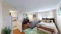 Located in New Orleans, LA, this well-appointed studio/one-bedroom unit offers a smartly designed, single-floor layout that maximizes every square foot. The main living area features warm hardwood flooring throughout and is finished with classic crown molding, lending a timeless character to the space. A large window allows natural light to fill the room, creating a bright and welcoming atmosphere. The open-concept design seamlessly integrates the sleeping area with the living space, providing flexibility in how the room is arranged and used.

The kitchen is positioned along one wall and separated from the main living area by a breakfast bar with seating for two, offering both a casual dining option and a natural visual divider. White cabinetry, a full-size refrigerator, an electric range, microwave, and sink provide all the essentials for everyday cooking.

A hallway leads to the full bathroom, which features tile flooring, a tub/shower combination with a decorative curtain, an extended vanity with a single sink, and a well-lit mirror. The layout is efficient and clean, with ample counter space.

Crown molding, consistent hardwood floors, and neutral wall tones tie the entire unit together, giving it a cohesive and comfortable feel suited for both short and long-term living in the heart of New Orleans.