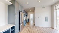 Located at 421 W Tremont Ave in Charlotte's vibrant Dilworth neighborhood, this one-bedroom, one-bathroom residence offers a well-designed layout with modern finishes throughout. Light wood-tone flooring runs seamlessly across the entire space, creating a warm, cohesive aesthetic.

The kitchen is a standout feature, showcasing slate-blue shaker cabinets with gold hardware, white quartz countertops, a white subway tile backsplash, and a full suite of stainless steel appliances including a range, microwave, dishwasher, and refrigerator. A matte black faucet adds a contemporary contrast to the clean, bright workspace.

The open living area flows naturally from the kitchen, offering generous space bathed in natural light. The bedroom is comfortably sized, featuring multiple windows with slatted blinds, a ceiling fan with light fixture, and access to a dedicated closet. Views of surrounding greenery are visible through the windows, adding a pleasant natural element.

The bathroom maintains the home's clean, modern palette with white cabinetry, a single vanity, and a bright window that brings in natural light. A private balcony rounds out the layout, providing an outdoor retreat. Recessed lighting throughout the unit completes the polished, move-in-ready feel of this Charlotte residence.