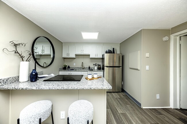 Bright kitchen with granite countertops and stainless steel appliances - The Collective at Sutherland