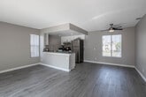Located at 800 E Washington St in Colton, California, this single-floor residence offers a well-designed, open-concept layout with consistent light wood-style flooring throughout. The combined kitchen and living area serves as the heart of the space, where a peninsula with dark countertops and white cabinetry connects the two zones seamlessly. The kitchen is equipped with stainless steel appliances, including a refrigerator, range, and dishwasher, complemented by recessed lighting and ample cabinet storage. The living area benefits from natural light through a vertical-blind window and is equipped with a ceiling fan for added comfort. A dedicated bedroom features mirrored sliding closet doors and its own window with outdoor views, while another room provides direct access to a private balcony through a sliding glass door, offering a connection to the outdoors. The bathrooms are finished with white vanity cabinetry, dark countertops, large mirrors, and light wood-style flooring, with one bathroom featuring a full tub and shower combination. Textured ceilings and neutral-toned walls create a clean, cohesive aesthetic throughout the entire space.