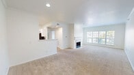 Located at 210 S Prairie View Dr in West Des Moines, Iowa, this single-floor, one-bedroom, one-bathroom residence offers a thoughtfully arranged layout across a comfortable footprint. The open-concept living room is a welcoming centerpiece, featuring plush carpeting, a white-mantled fireplace with tile surround, and a large window that fills the space with natural light and outdoor views. The layout flows seamlessly into the kitchen, which is separated by a peninsula counter. The kitchen is outfitted with white cabinetry accented by black hardware, light quartz countertops, hardwood-style flooring, and a full suite of stainless steel appliances including a range, over-the-range microwave, and dishwasher. The spacious bedroom features soft carpeting, a ceiling fan with light, and a generous window. It provides direct access to a dedicated closet and is conveniently connected to the bathroom, which includes a tub/shower combo with white tile surround, a white vanity with quartz countertop, and hardwood-style flooring. Additional highlights include a hallway connecting the main living areas, an in-unit laundry space, and a clean, bright aesthetic with white walls and trim throughout.