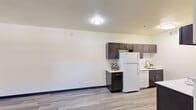 This single-floor residence features 3 bedrooms, 2 bathrooms, and a practical layout designed for comfortable everyday living. Wood-look plank flooring runs consistently throughout the home, complemented by neutral-toned walls and dark baseboards that provide a clean, modern contrast.

The galley-style kitchen is well-appointed with dark espresso cabinetry, white countertops, and a full suite of white appliances including a refrigerator, range, microwave, and dishwasher. The layout maximizes counter and storage space efficiently.

The primary bedroom includes a ceiling fan, sliding glass door leading to an outdoor balcony or patio, and generous natural light. A spacious walk-in closet with built-in shelving and hanging rods provides ample storage. Additional bedrooms are bright and versatile, each with sliding-door closets.

Both bathrooms feature a tub-shower combination with curtain rod, a vanity with light countertops, and dark cabinetry. One bathroom includes additional built-in shelving for extra storage convenience.

The home also includes a hallway connecting the rooms and a dedicated closet space. Flush-mount ceiling lighting is found throughout, giving the space a clean, uniform appearance well-suited for a range of lifestyles.