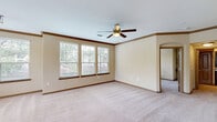 Located at 2500 S Millbend Dr in Spring, TX, this single-story, 3-bedroom, 3-bathroom home offers a thoughtfully designed layout across a generous footprint. The open-concept living, dining, and kitchen area serves as the heart of the home, with plush carpeting and multiple windows flooding the space with natural light and views of the surrounding neighborhood greenery. Crown molding and ceiling fans are featured throughout, adding a polished touch to each room.

The kitchen is well-equipped with rich dark cabinetry, granite countertops, a mosaic tile backsplash, and black appliances including a refrigerator, range, and built-in microwave. Tile flooring and ample storage—including a pantry—make this an efficient and stylish cooking space.

The spacious primary bedroom features crown molding, a ceiling fan, and large windows, complemented by a luxurious en-suite bathroom with dual granite vanities, a soaking tub, and a separate glass-enclosed shower. Two additional bedrooms offer ceiling fans, carpeted floors, and closet space—one notably including built-in shelving and a desk nook. A total of five closets provide abundant storage throughout.

Secondary bathrooms include granite vanities, tile flooring, and tub-shower combos with arched architectural detailing. A dedicated laundry room, hallway, and patio round out this functional and inviting home.